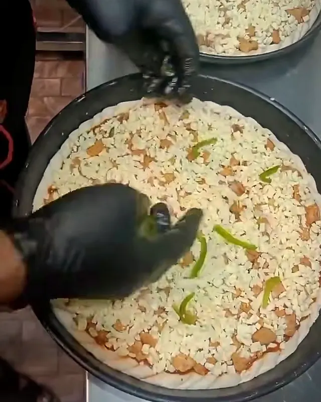 Toppings added to a pizza in the pan